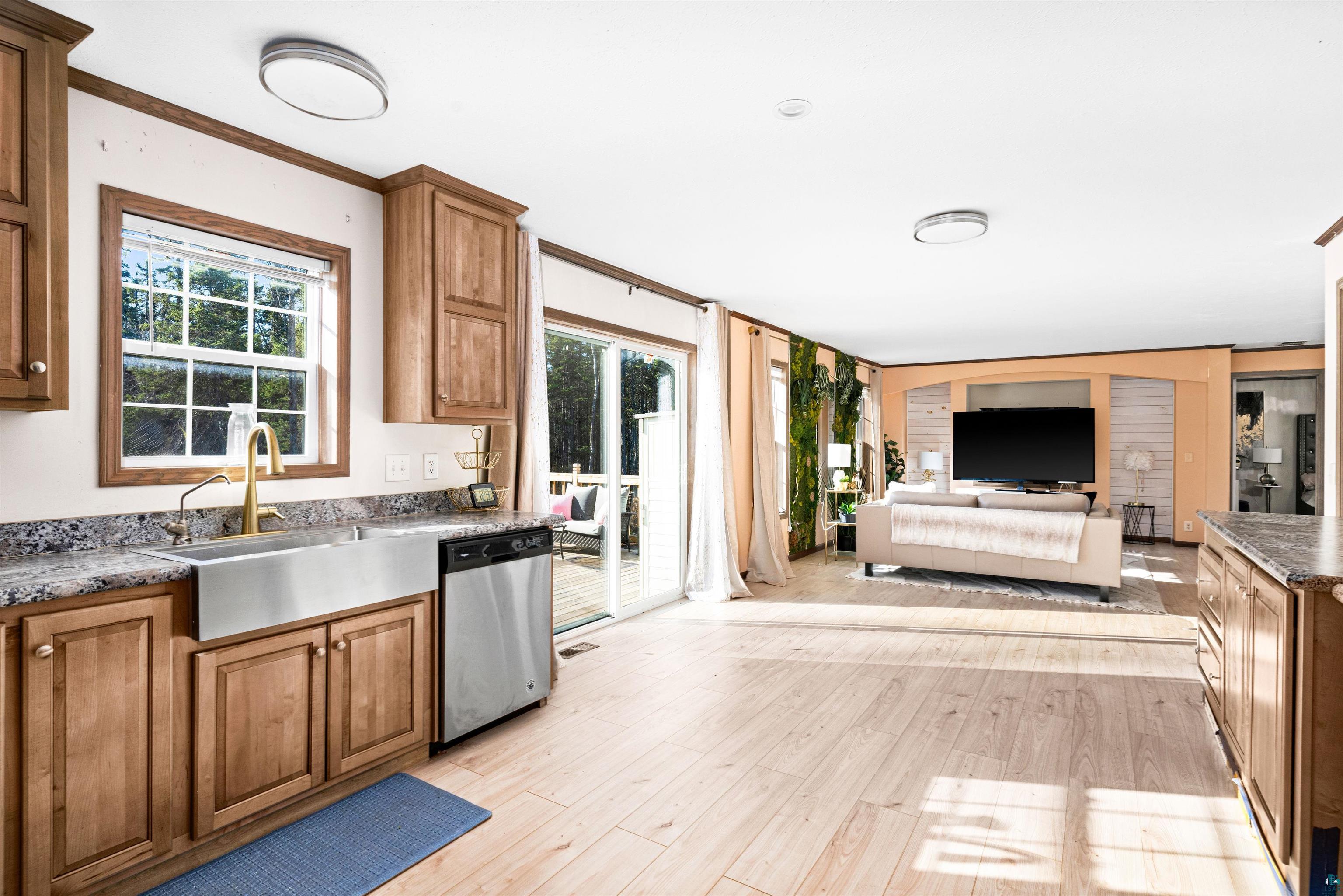 5562 Lavaque Road Duluth, MN 55803 - Photo 12 of 28 Kitchen featuring plenty of natural light, crown molding, light hardwood / wood-style flooring, and stainless steel dishwasher
