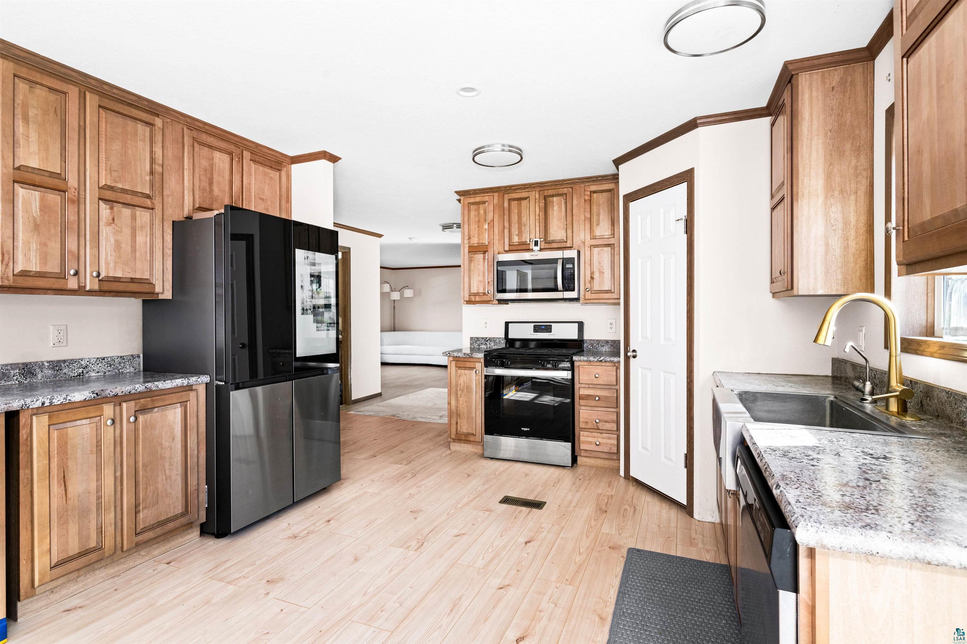 5562 Lavaque Road Duluth, MN 55803 - Photo 13 of 28 Kitchen featuring appliances with stainless steel finishes, light hardwood / wood-style flooring, ornamental molding, and sink