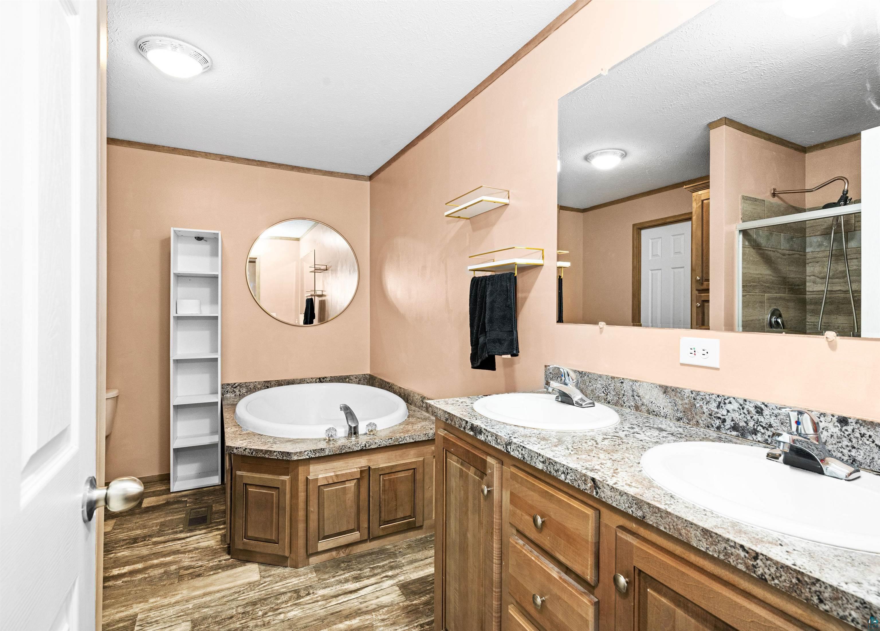 5562 Lavaque Road Duluth, MN 55803 - Photo 18 of 28 Bathroom with separate shower and tub, a textured ceiling, wood-type flooring, ornamental molding, and vanity