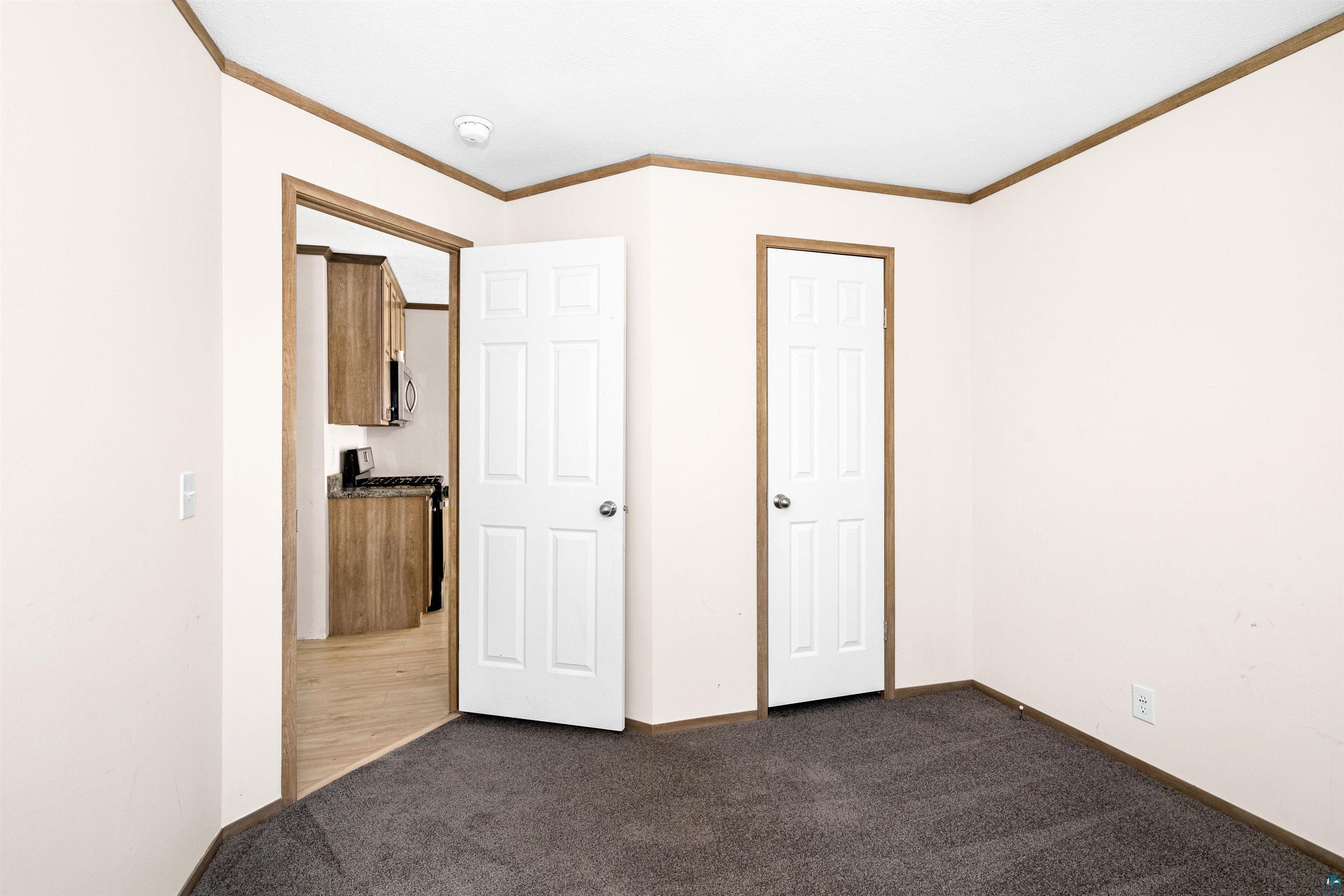 5562 Lavaque Road Duluth, MN 55803 - Photo 25 of 28 Unfurnished bedroom featuring crown molding and dark colored carpet
