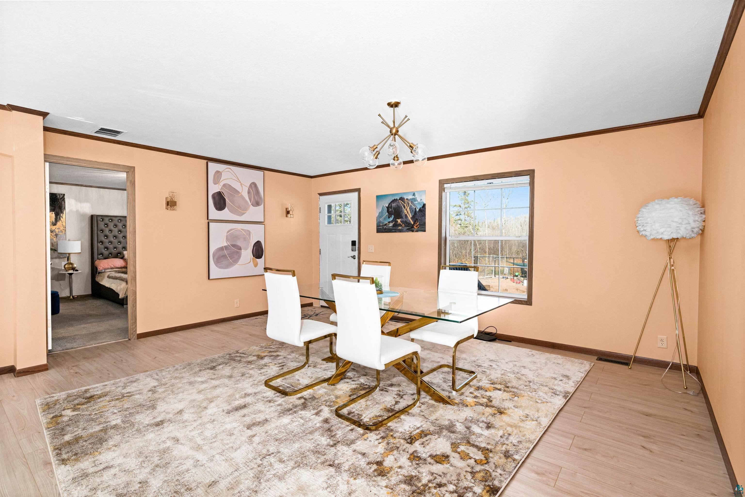 5562 Lavaque Road Duluth, MN 55803 - Photo 10 of 28 Unfurnished dining area featuring ornamental molding, a notable chandelier, and light hardwood / wood-style floors