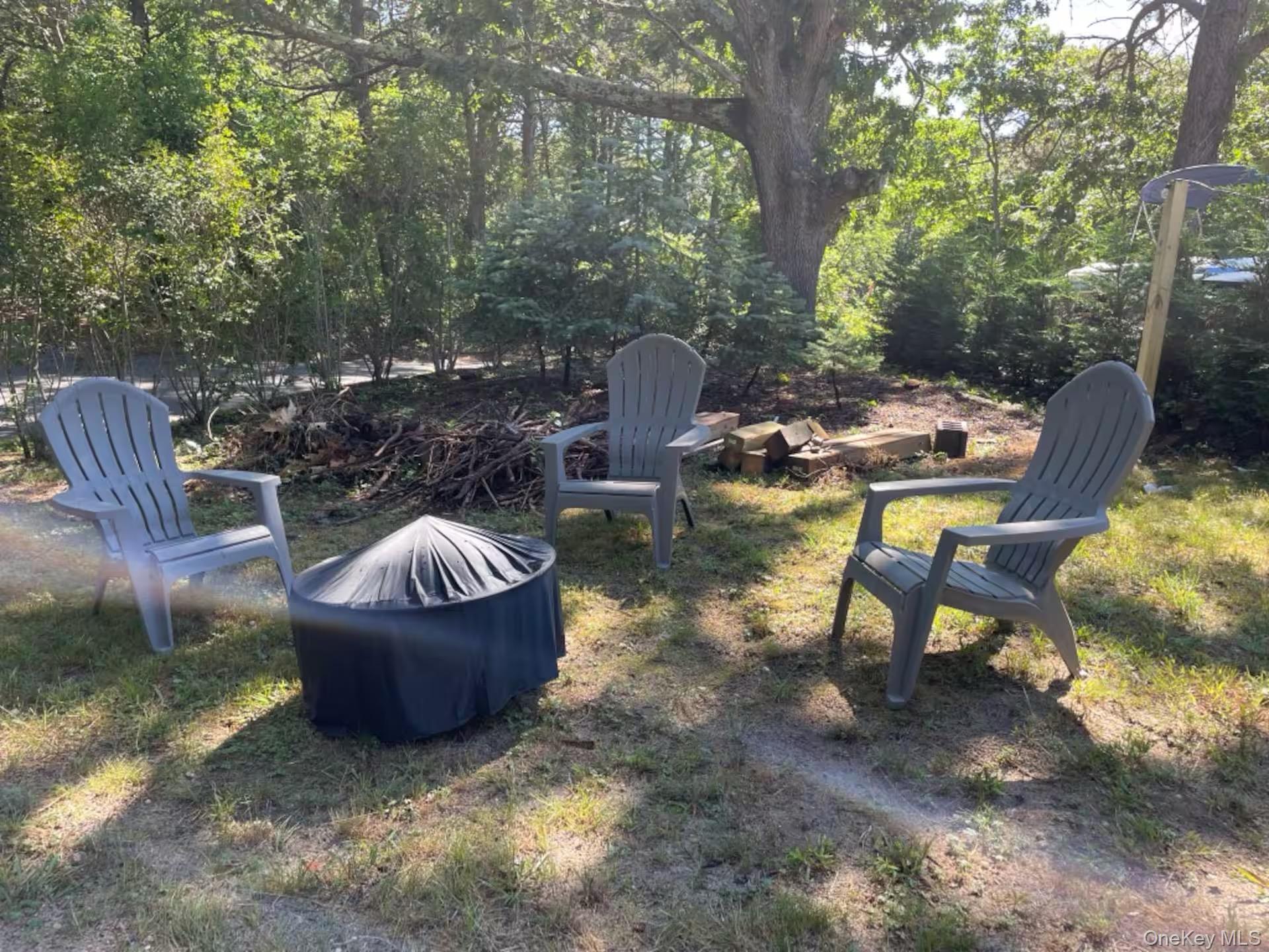 332 Canoe Place Road Southampton, NY 11968 - Photo 16 of 19 a view of a swimming pool with a patio and a fire pit
