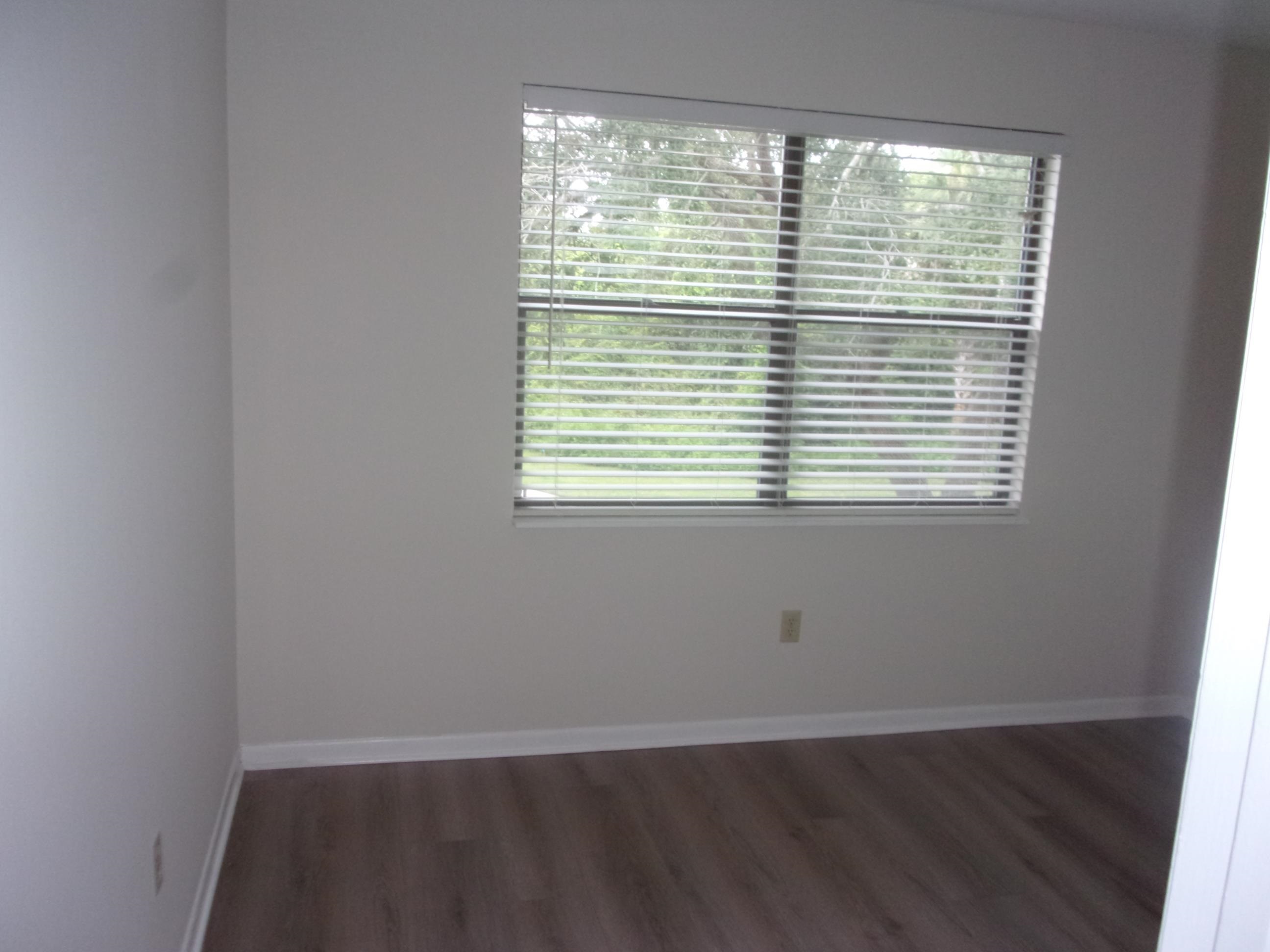 700 West Pope Road St. Augustine, FL 32080 - Photo 26 of 32 a view of an empty room with wooden floor and a window