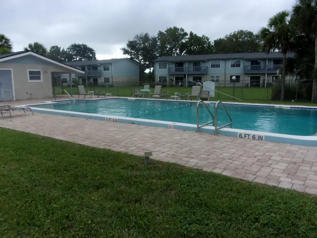 a view of a house in a big yard with plants and large trees