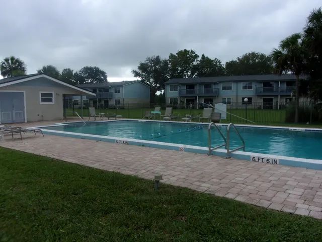 a view of a house with a yard and a large tree