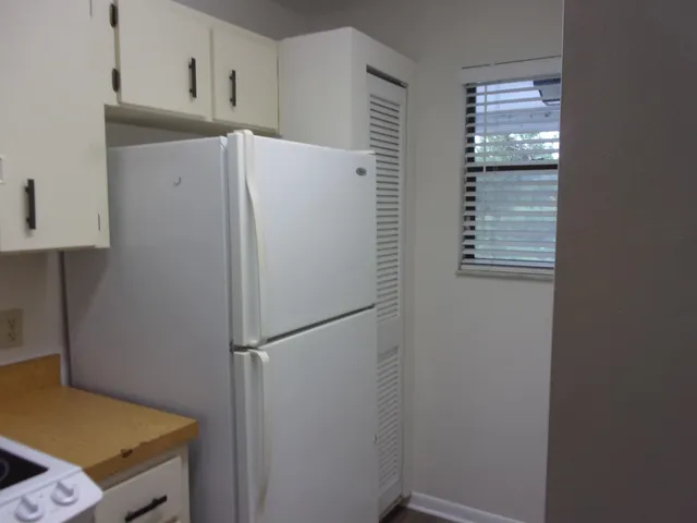 a white refrigerator freezer and a stove sitting inside of a kitchen
