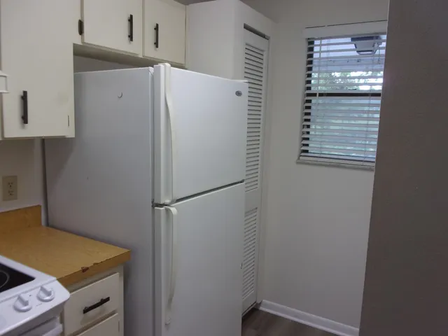 a white refrigerator freezer and a stove sitting inside of a kitchen