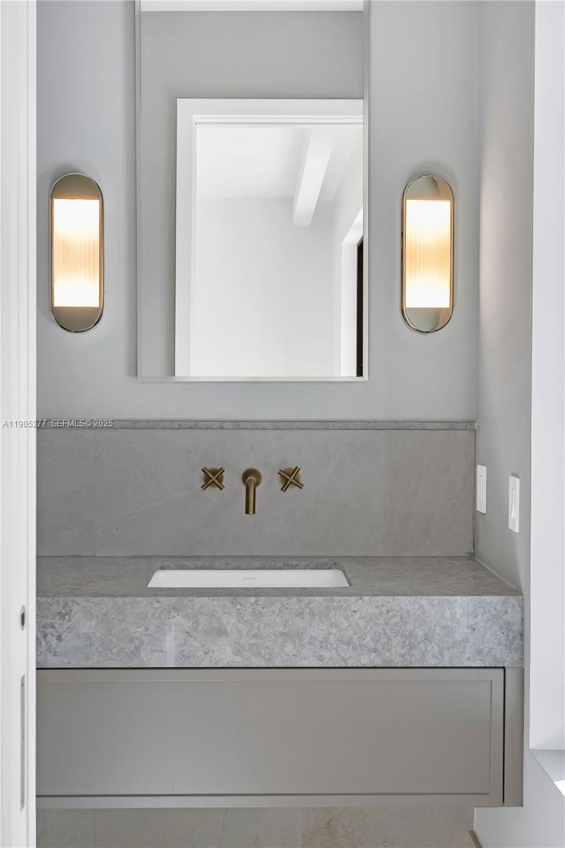 4191 Battersea Road Miami, FL 33133 - Photo 23 of 27 a bathroom with a mirror and a sink