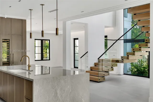 a room with lots of white furniture and stairs