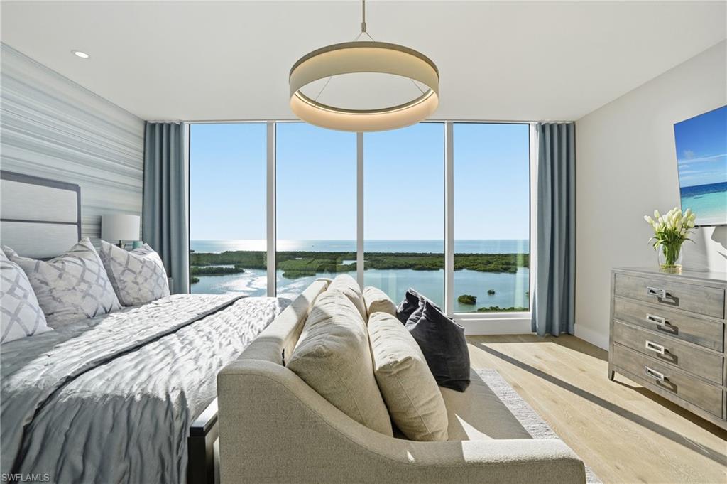 13945 Old Coast Road, Unit 1906 Naples, FL 34110 - Photo 12 of 40 a bedroom with a bed and a large window