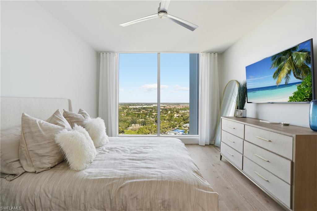 13945 Old Coast Road, Unit 1906 Naples, FL 34110 - Photo 16 of 40 a bedroom with a large bed and a window