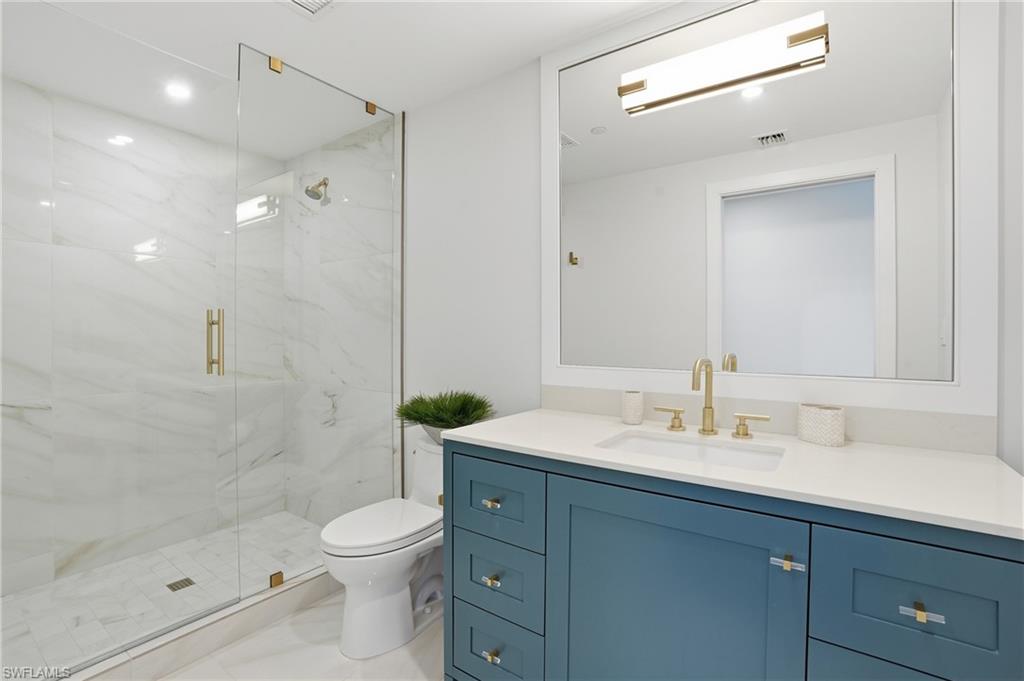 13945 Old Coast Road, Unit 1906 Naples, FL 34110 - Photo 17 of 40 a bathroom with a sink a toilet and shower
