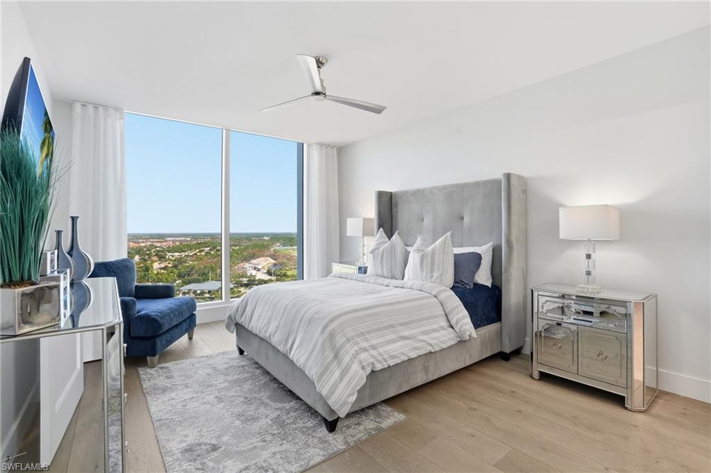 13945 Old Coast Road, Unit 1906 Naples, FL 34110 - Photo 18 of 40 a bedroom with a bed couch and large window