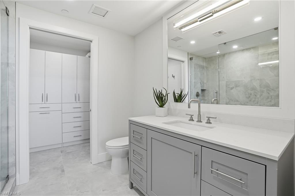 13945 Old Coast Road, Unit 1906 Naples, FL 34110 - Photo 19 of 40 a bathroom with a sink a toilet and a large mirror