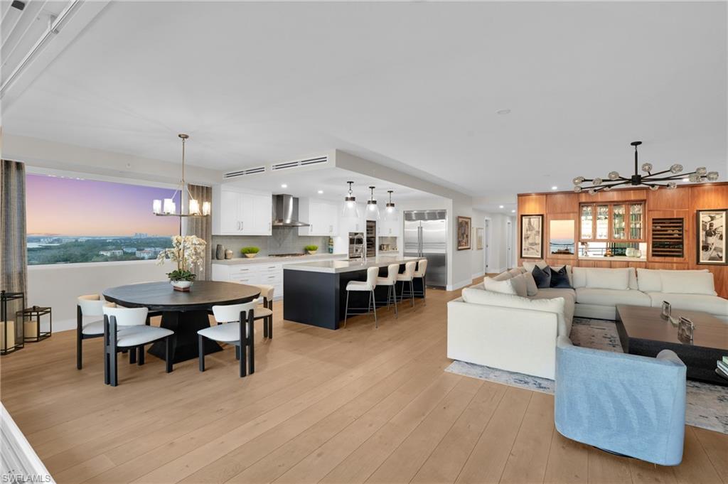 13945 Old Coast Road, Unit 1906 Naples, FL 34110 - Photo 27 of 40 a living room with furniture a fireplace and a floor to ceiling window