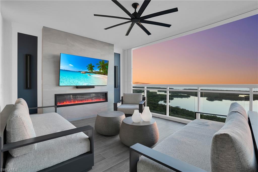 13945 Old Coast Road, Unit 1906 Naples, FL 34110 - Photo 29 of 40 a living room with furniture a ceiling fan and a flat screen tv