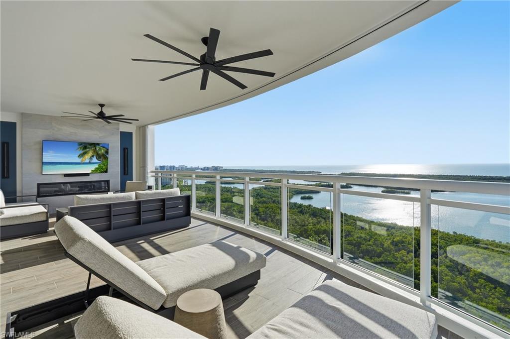 13945 Old Coast Road, Unit 1906 Naples, FL 34110 - Photo 3 of 40 a living room with furniture a ceiling fan and a large window