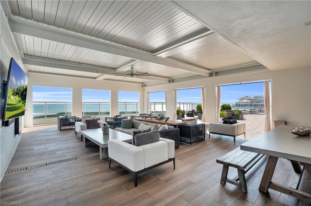 13945 Old Coast Road, Unit 1906 Naples, FL 34110 - Photo 37 of 40 a living room with fireplace furniture and a wooden floor