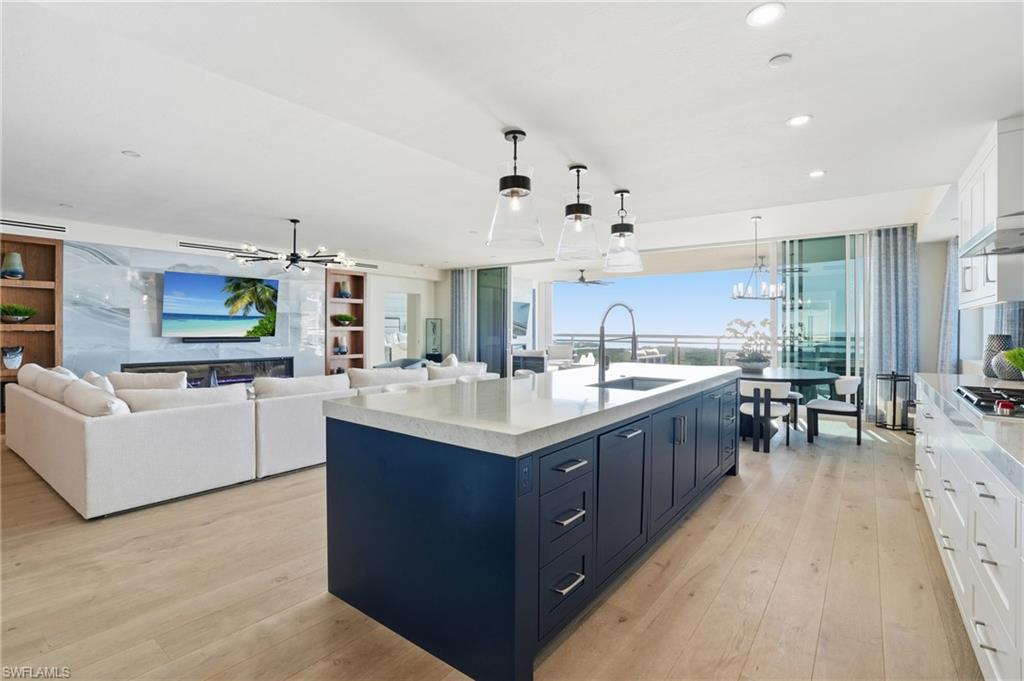 13945 Old Coast Road, Unit 1906 Naples, FL 34110 - Photo 6 of 40 a kitchen with stainless steel appliances kitchen island granite countertop a sink counter top space and cabinets