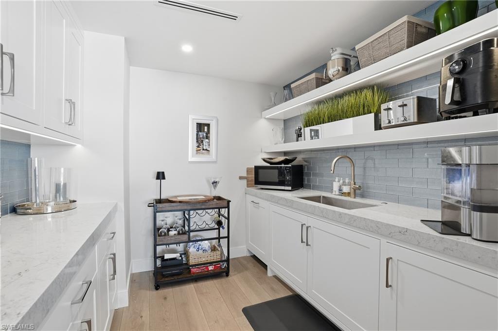 13945 Old Coast Road, Unit 1906 Naples, FL 34110 - Photo 9 of 40 a kitchen with stainless steel appliances granite countertop a sink stove and cabinets
