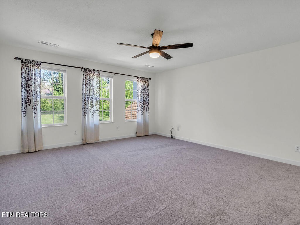 7425 Lawford Road Knoxville, TN 37919 - Photo 44 of 57 an empty room with windows and ceiling fan