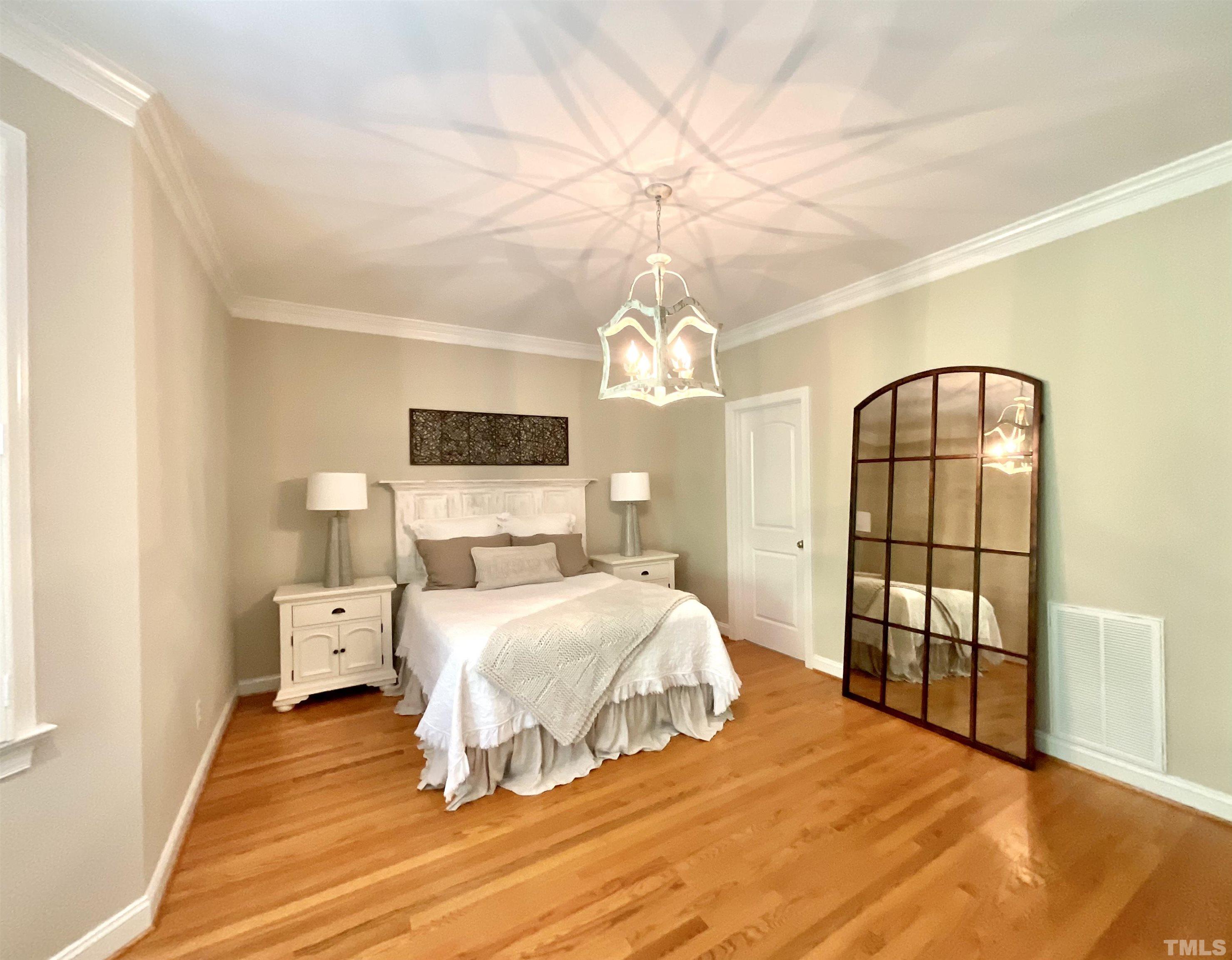 4300 Dula Street Durham, NC 27705 - Photo 23 of 42 a bedroom with a large bed and a chandelier