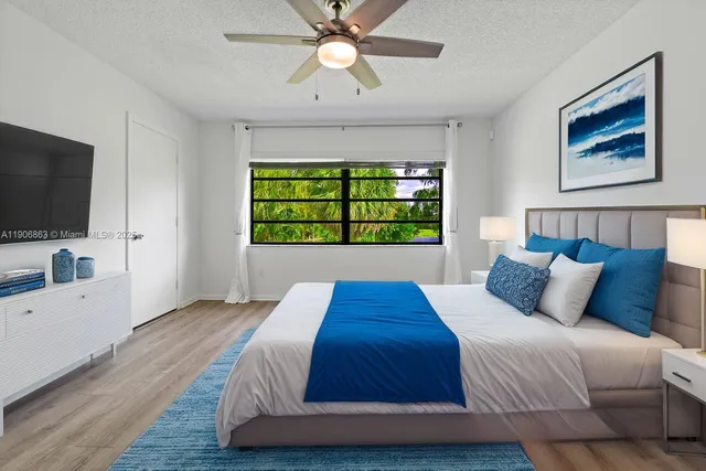 a bedroom with a large bed a flat tv screen and a bookshelf