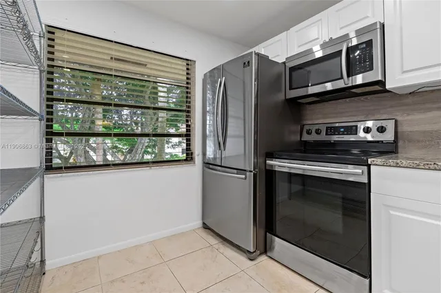 a kitchen with stainless steel appliances granite countertop a stove microwave and refrigerator