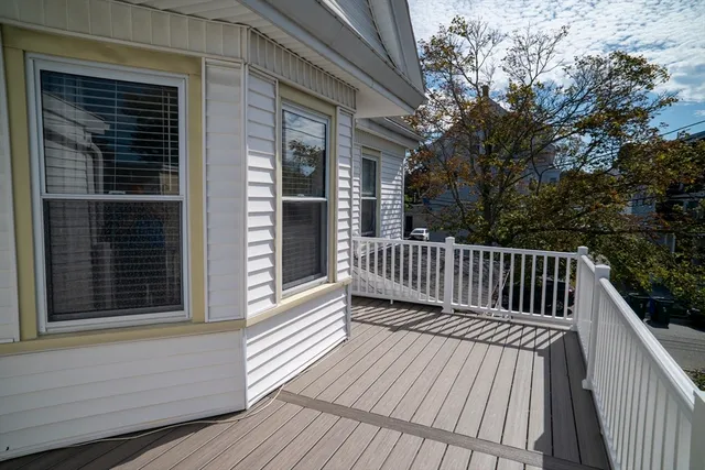 a view of deck with a large window and wooden fence