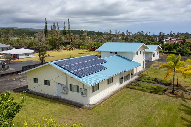 a aerial view of a house with a swimming pool and a yard