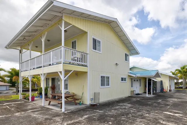 a view of a house with a patio and a yard