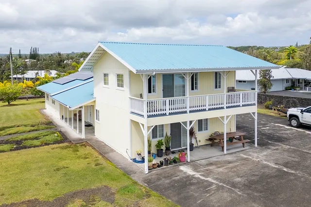 a view of a house with a yard and sitting area
