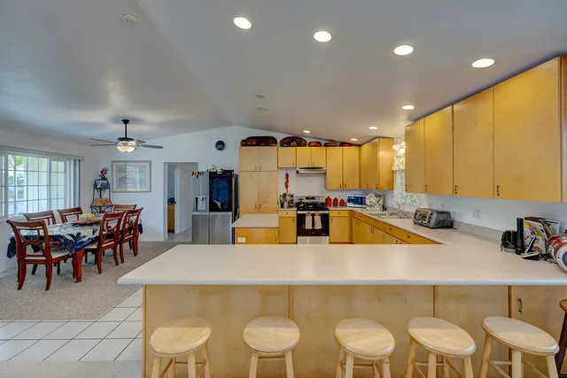 a kitchen with a dining table chairs and white appliances