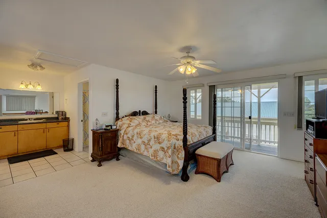 a spacious bedroom with a bed a couch and a chandelier