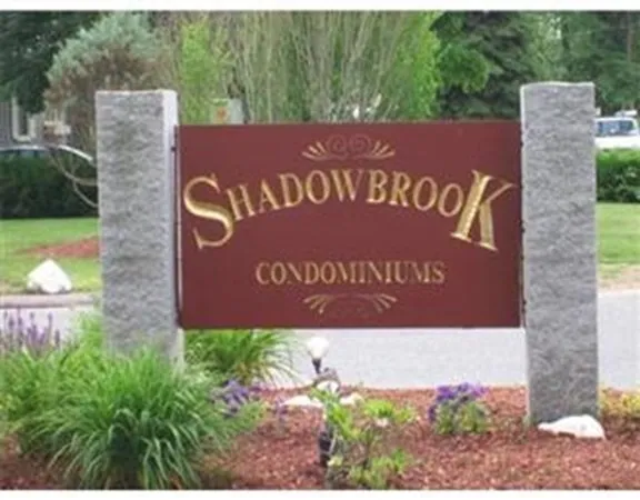 a sign that is sitting on a brick wall