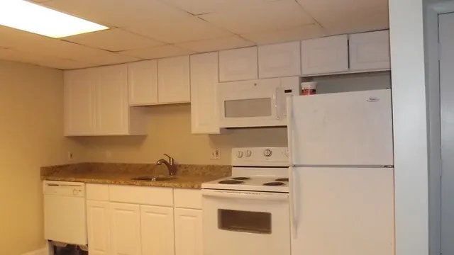 a kitchen with stainless steel appliances granite countertop white refrigerator stove a sink and dishwasher