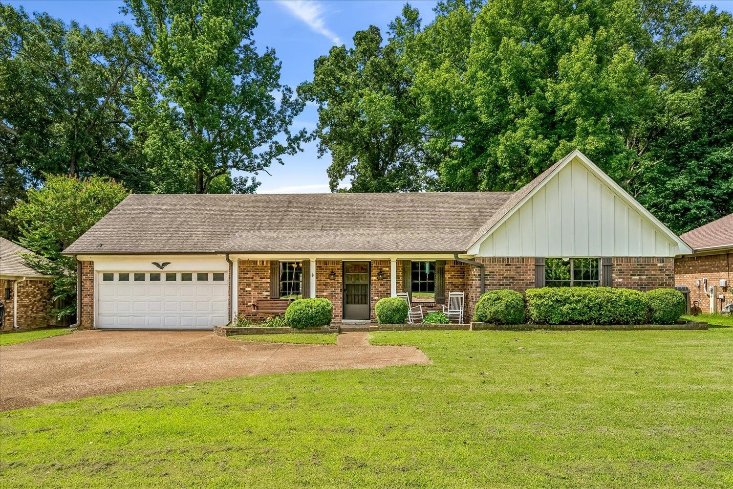 5711 Yale Road Bartlett, TN 38134 - Photo 1 of 29 Brick exterior with an attached garage, covered front porch, a well-maintained lawn, and mature trees providing natural screening