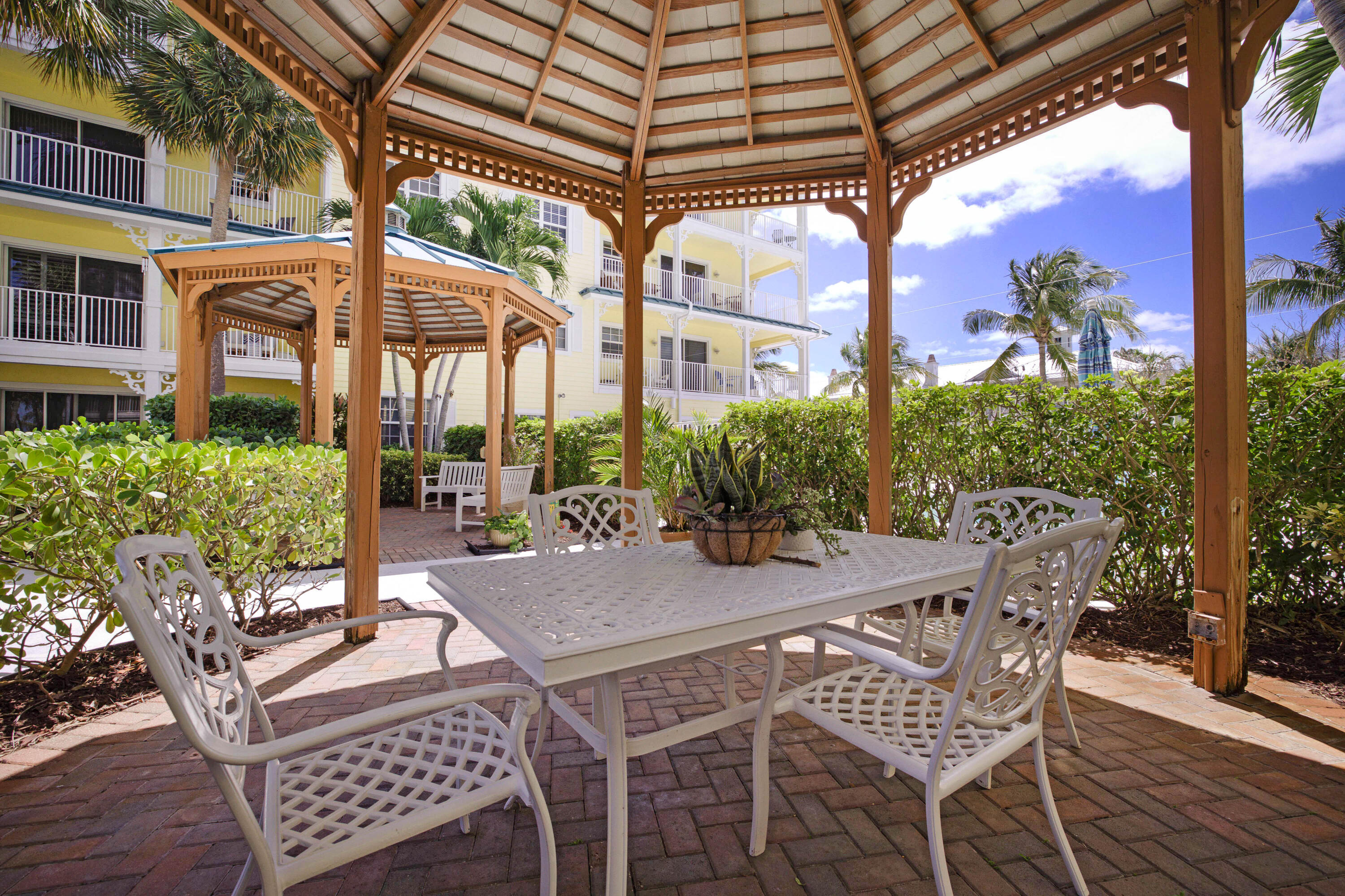 810 Juno Ocean Walk, Unit 401B Juno Beach, FL 33408 - Photo 43 of 57 a view of an outside dining space with a table and chairs