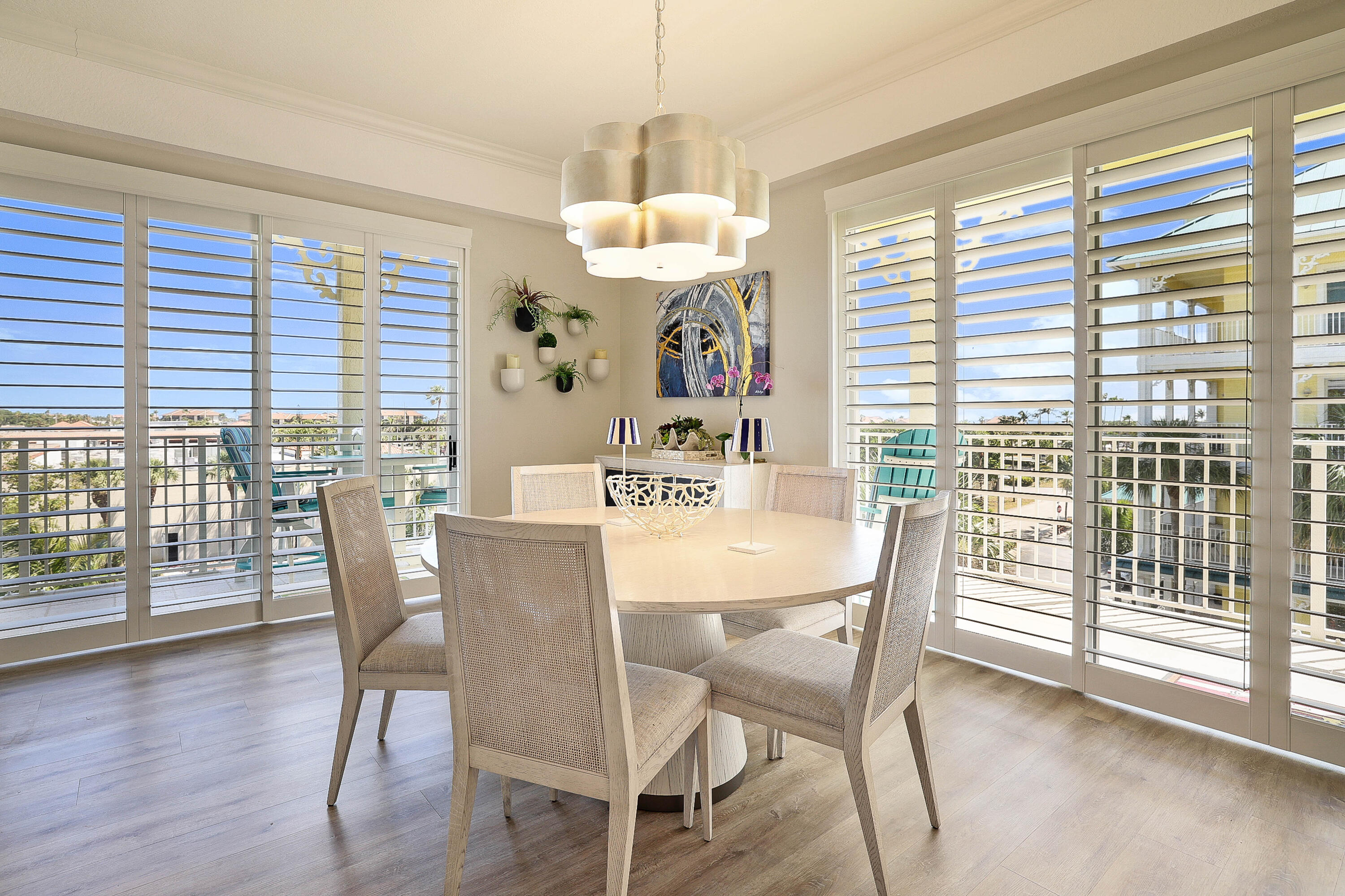 810 Juno Ocean Walk, Unit 401B Juno Beach, FL 33408 - Photo 5 of 57 a dining room with wooden floor a chandelier a glass table and chairs