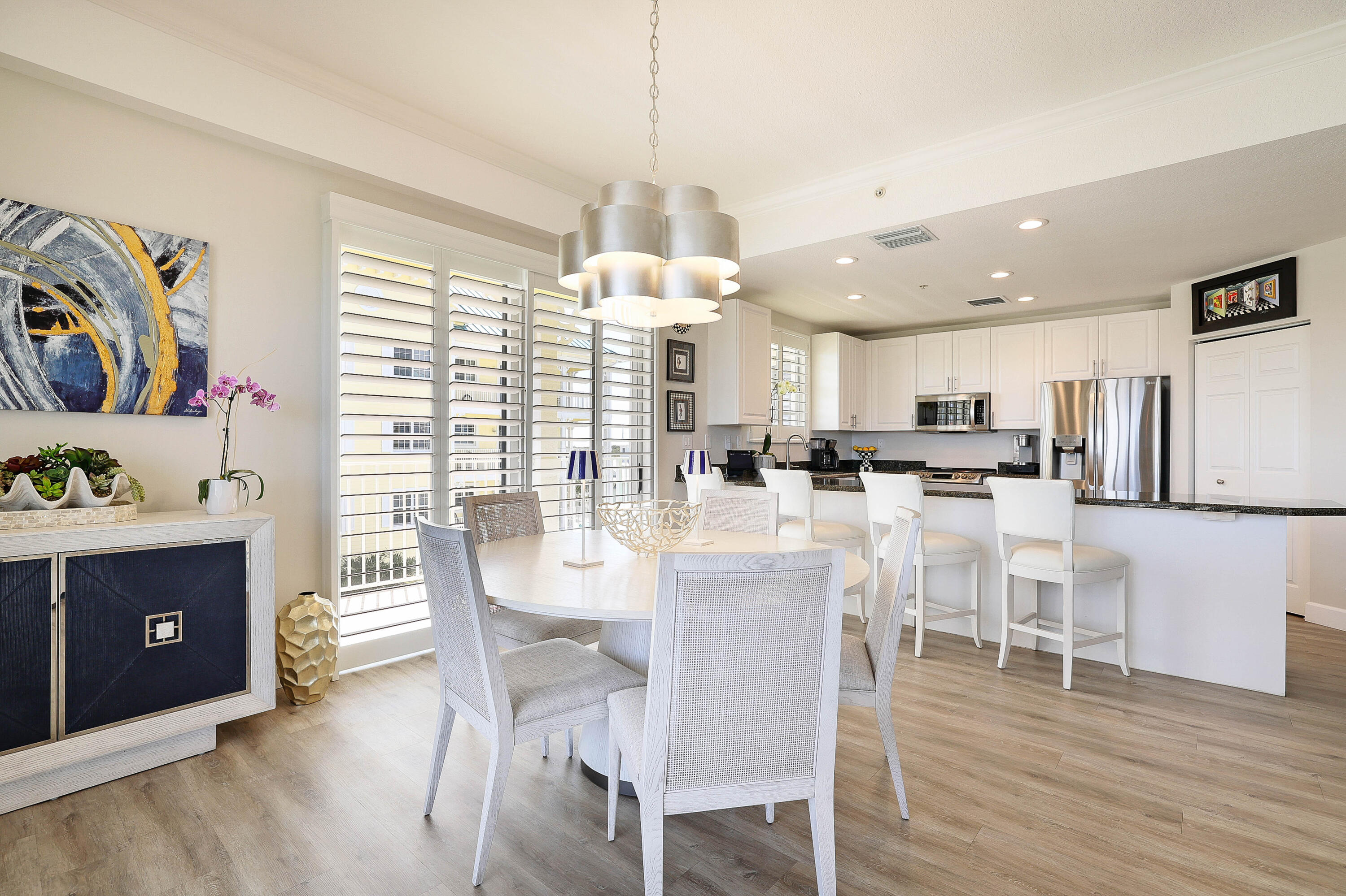 810 Juno Ocean Walk, Unit 401B Juno Beach, FL 33408 - Photo 6 of 57 a dining room with kitchen island stainless steel appliances furniture a dining table and chairs