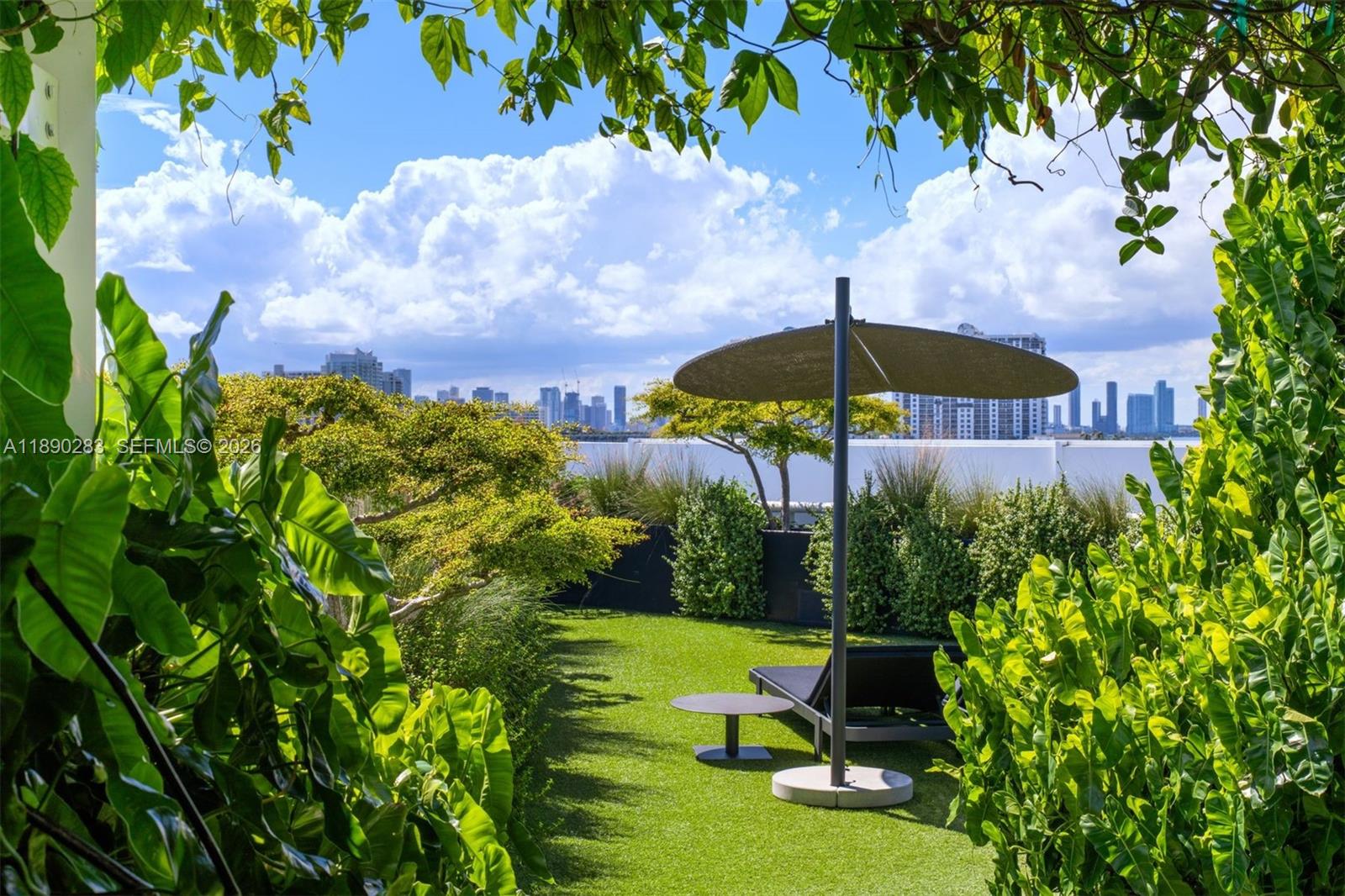 2001 Meridian Avenue, Unit PH01 Miami Beach, FL 33139 - Photo 53 of 63 a view of a table and chairs under an umbrella in the garden