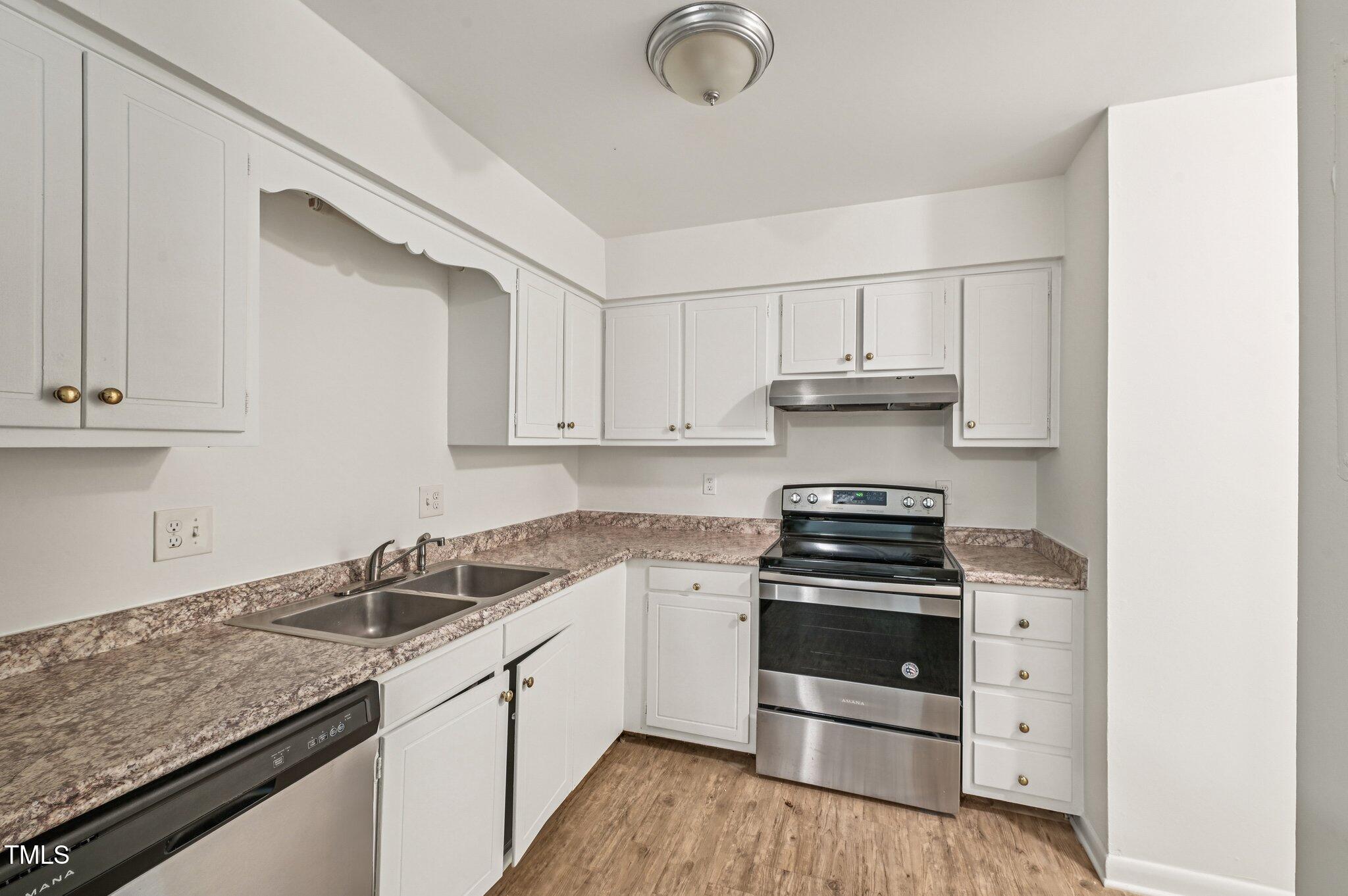 642 Pine Ridge Place Raleigh, NC 27609 - Photo 4 of 15 a kitchen with granite countertop a stove and a sink