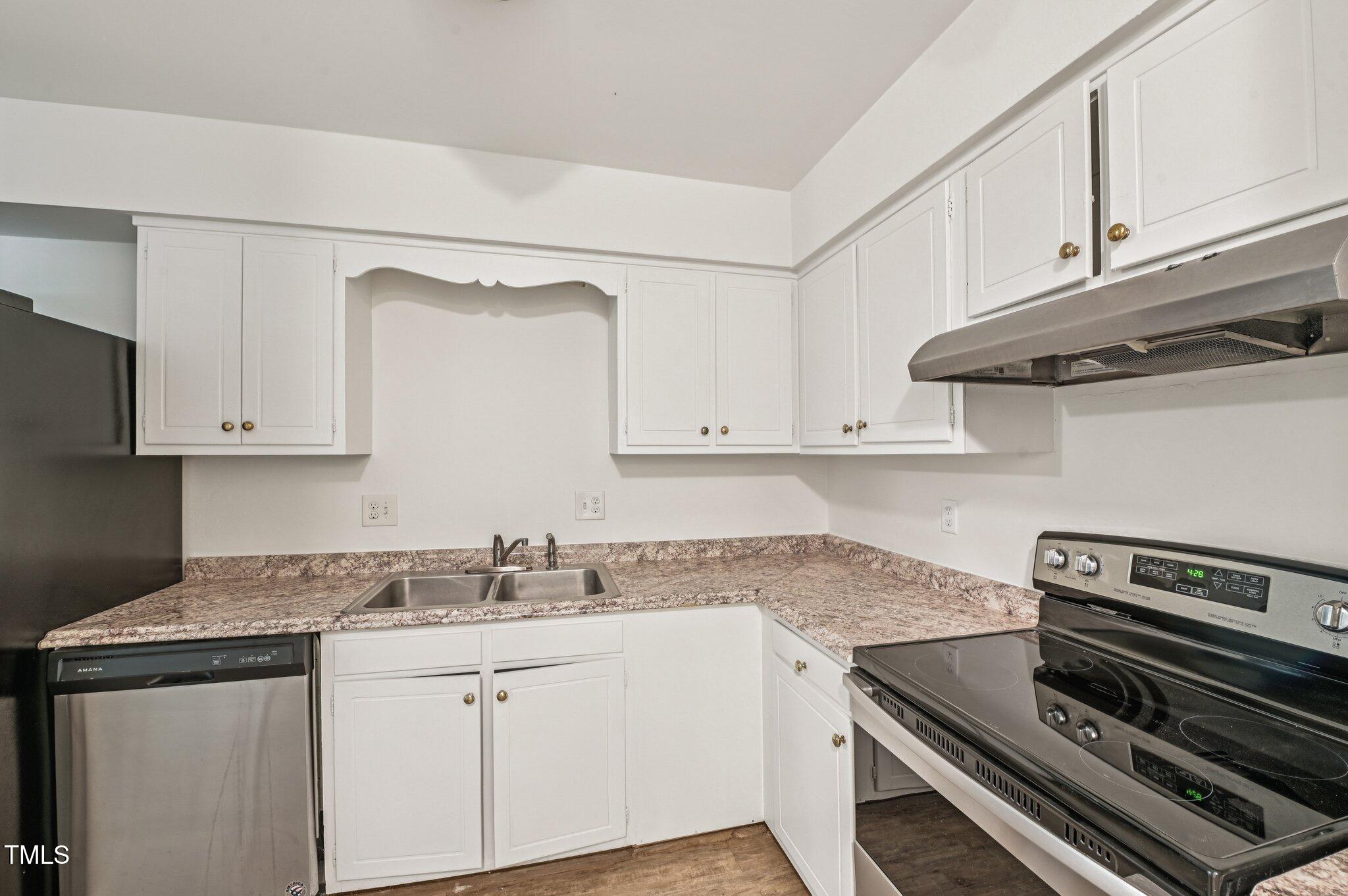 642 Pine Ridge Place Raleigh, NC 27609 - Photo 5 of 15 a kitchen with granite countertop white cabinets and white appliances