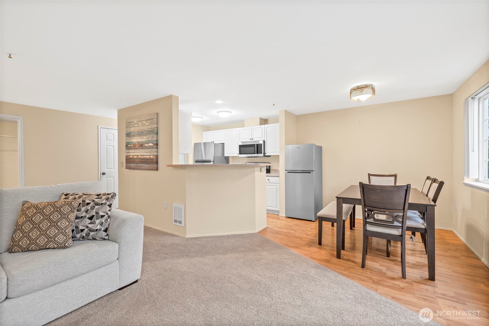 10824 Southeast 170th Street, Unit B103 Renton, WA 98055 - Photo 5 of 31 a living room with furniture and kitchen view