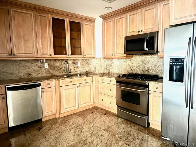 a kitchen with granite countertop a sink stainless steel appliances and cabinets