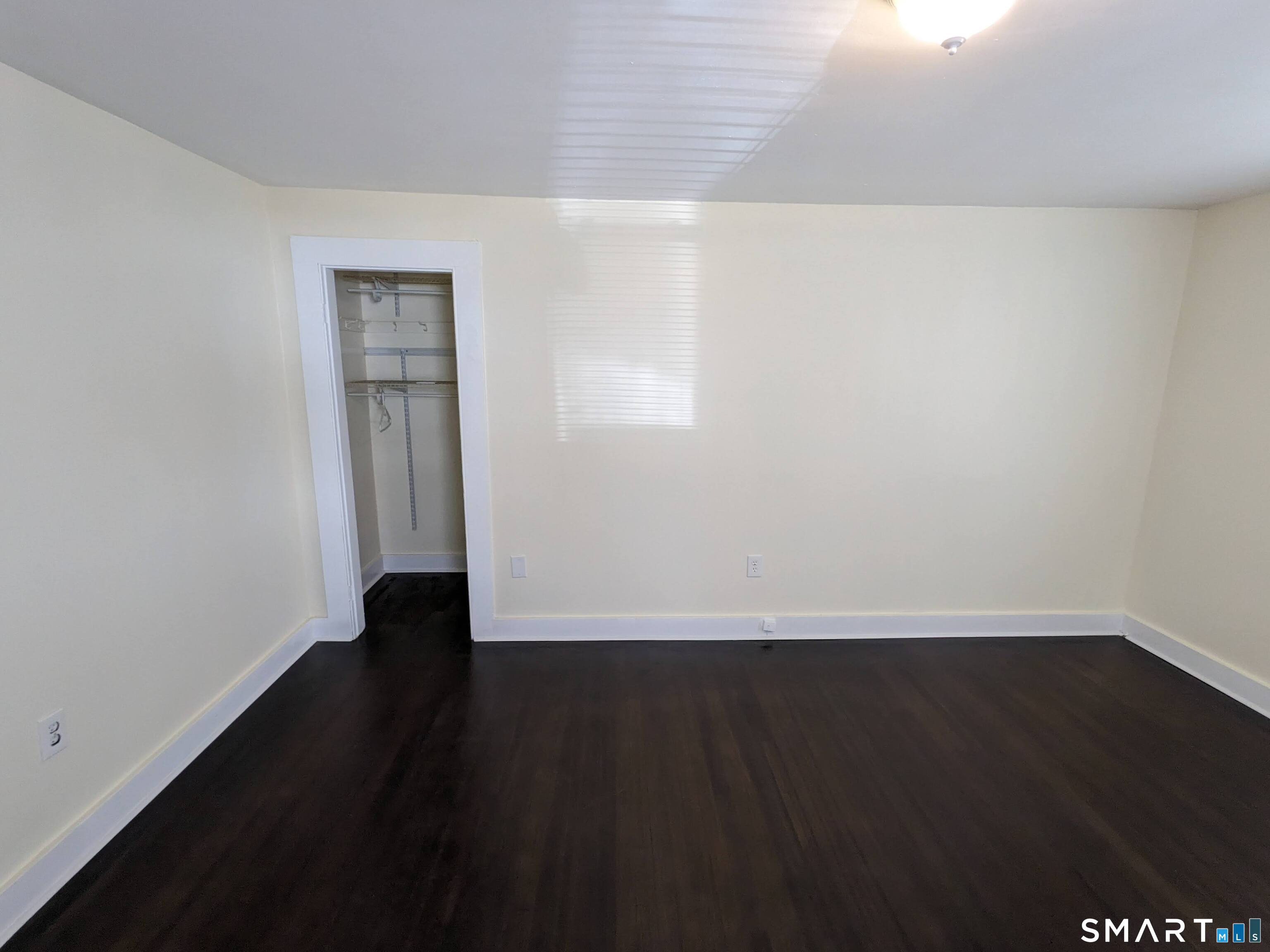 232 Hawkins Street Derby, CT 06418 - Photo 16 of 27 a view of an empty room with wooden floor and a window