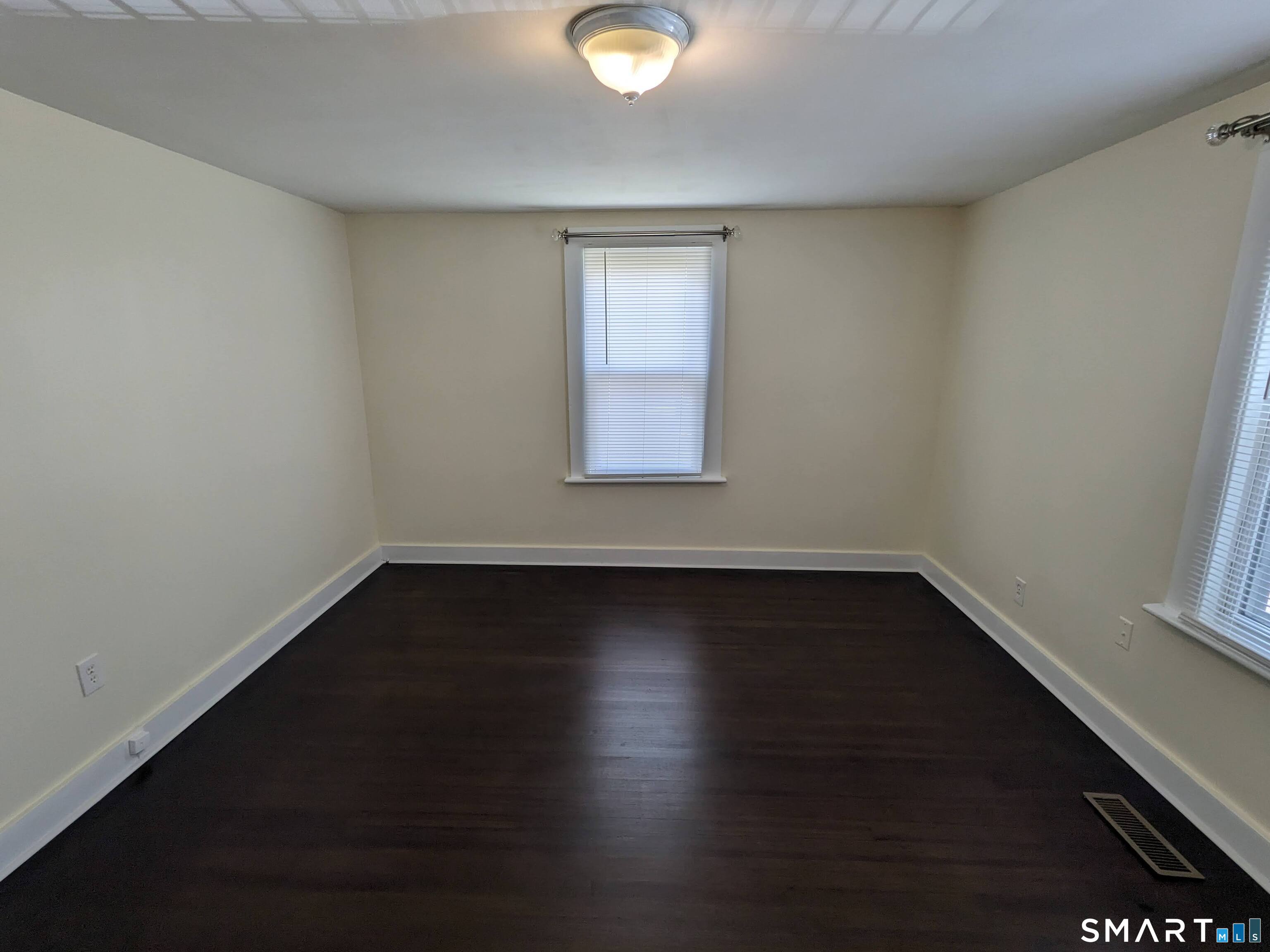 232 Hawkins Street Derby, CT 06418 - Photo 17 of 27 a view of an empty room with wooden floor and a window