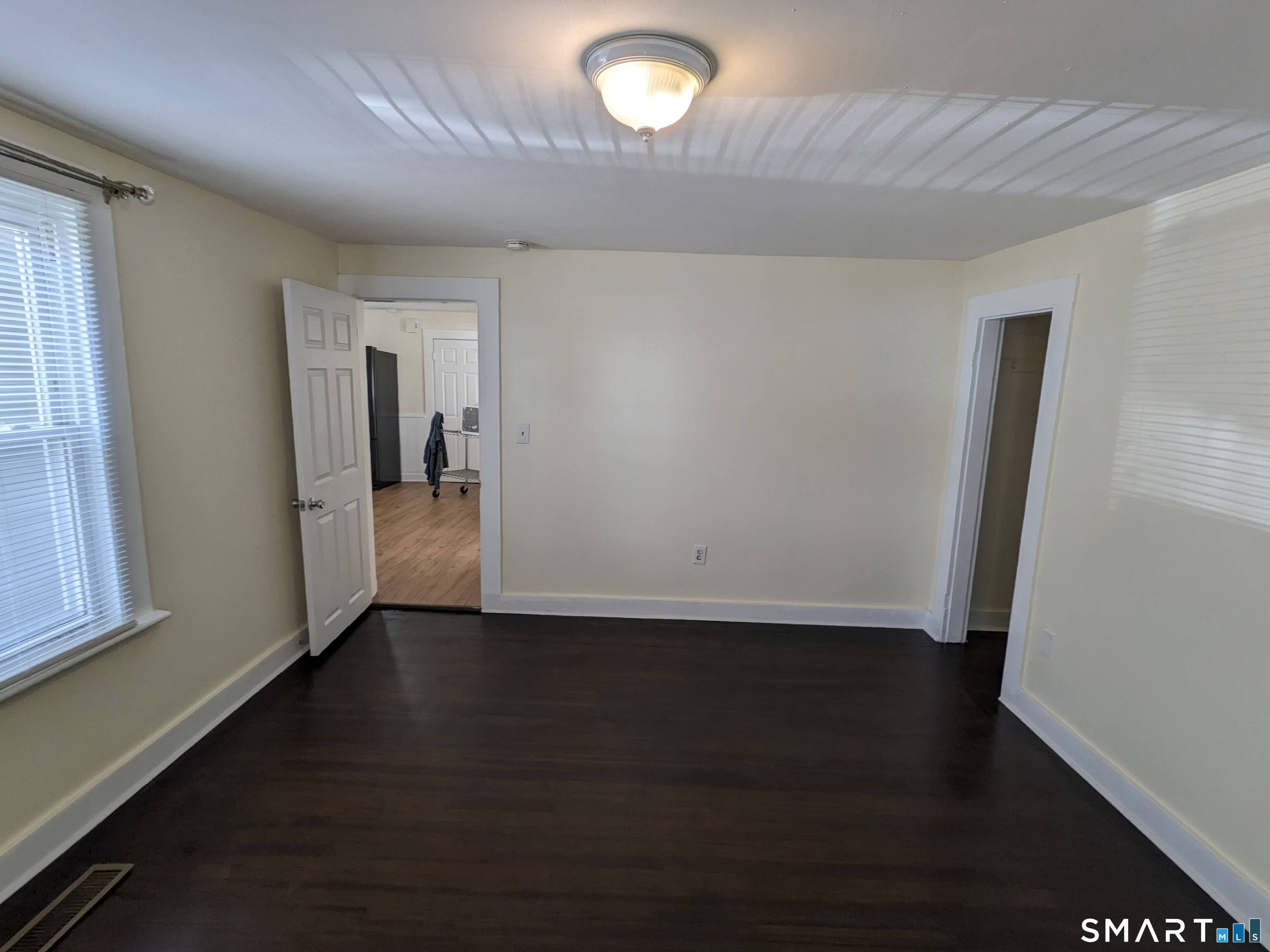 232 Hawkins Street Derby, CT 06418 - Photo 18 of 27 an empty room with wooden floor and windows