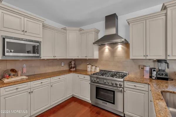 a kitchen with stainless steel appliances granite countertop a sink a stove and cabinets
