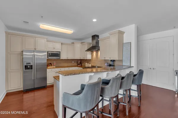 a kitchen with stainless steel appliances a dining table chairs and a refrigerator